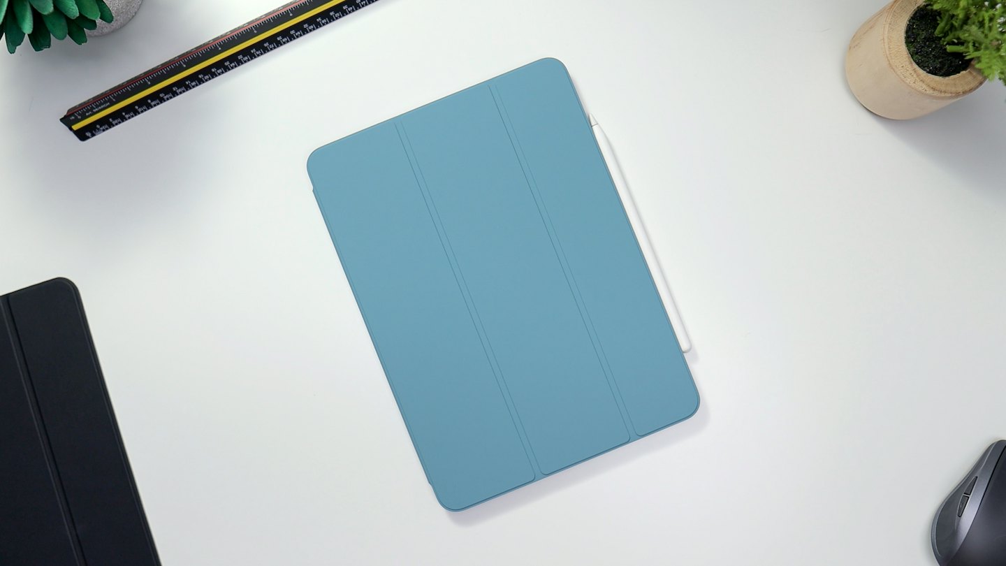 Tablet with stylus and office supplies arranged on a desk.
