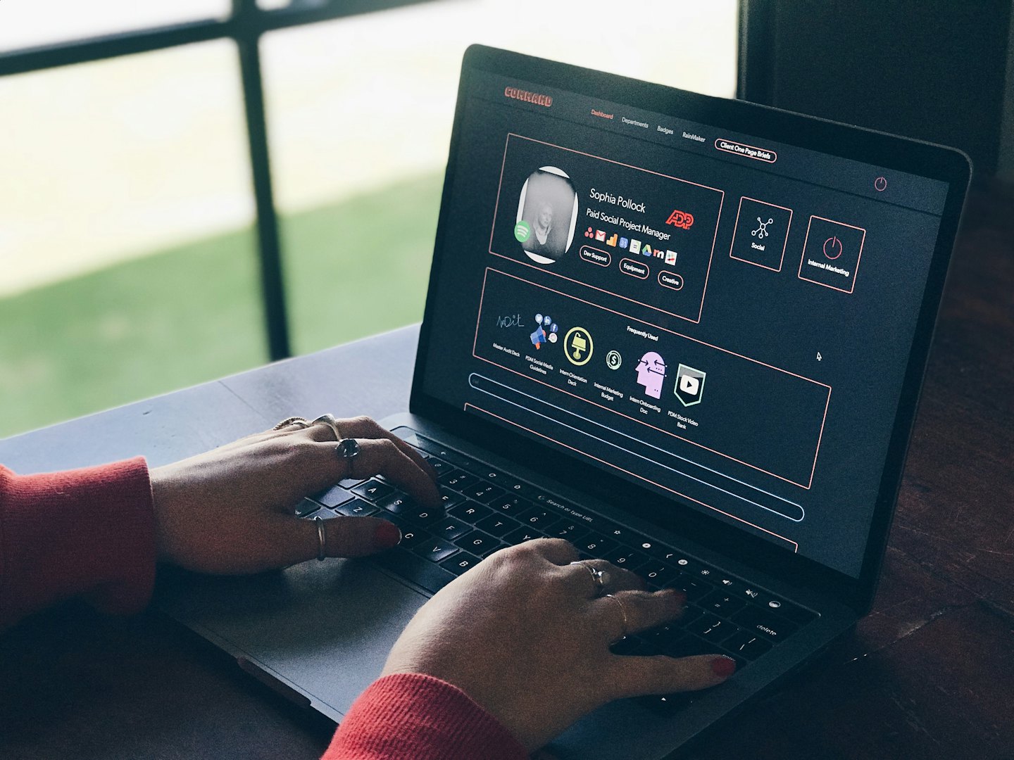 Hands typing on a laptop with custom software.